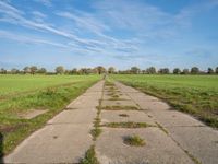 a pathway in a rural area with no cars on it and a blue sky above