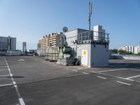 a photo of the side of a building with an antenna on it and buildings behind it