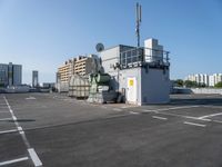 a photo of the side of a building with an antenna on it and buildings behind it