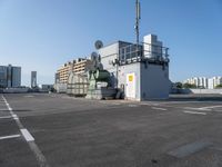 a photo of the side of a building with an antenna on it and buildings behind it