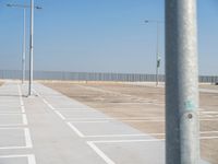 a parking lot with street lamps and poles at the end of it's row