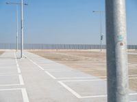 a parking lot with street lamps and poles at the end of it's row