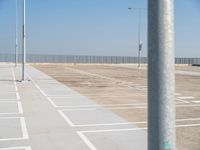 a parking lot with street lamps and poles at the end of it's row