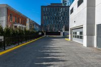 a sidewalk is in the middle of some buildings with a man walking down it on the street