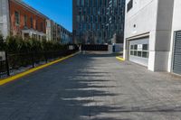 a sidewalk is in the middle of some buildings with a man walking down it on the street