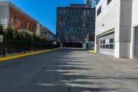 a sidewalk is in the middle of some buildings with a man walking down it on the street