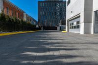 a sidewalk is in the middle of some buildings with a man walking down it on the street