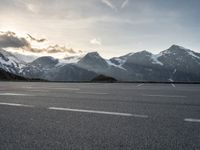 the sky is clear above mountains and a car in an empty parking lot with a mountain backdrop