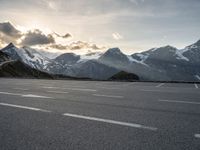 the sky is clear above mountains and a car in an empty parking lot with a mountain backdrop