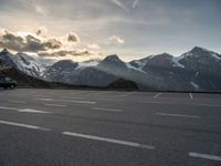 the sky is clear above mountains and a car in an empty parking lot with a mountain backdrop