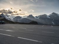 the sky is clear above mountains and a car in an empty parking lot with a mountain backdrop