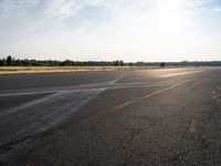 a young woman wearing a pink shirt is flying a kite in the distance while on the tarmac