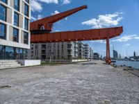 an image of a city setting with the water in front of it, and a large crane lifting people on to the side