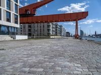 an image of a city setting with the water in front of it, and a large crane lifting people on to the side