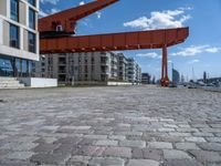 an image of a city setting with the water in front of it, and a large crane lifting people on to the side