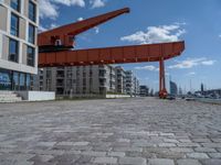 an image of a city setting with the water in front of it, and a large crane lifting people on to the side