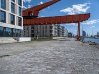 an image of a city setting with the water in front of it, and a large crane lifting people on to the side