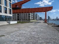 an image of a city setting with the water in front of it, and a large crane lifting people on to the side