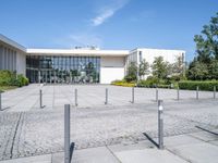 a building with a parking meter sitting in the middle of a courtyard with poles to provide a sidewalk way