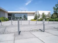 a building with a parking meter sitting in the middle of a courtyard with poles to provide a sidewalk way