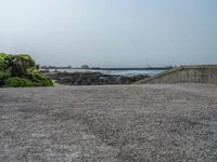 the empty parking lot has a water feature on it's wall and beach area with rock formations