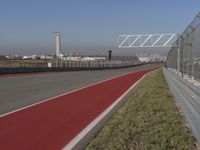 an empty track at a motorsports club with some red and white stripeing on it