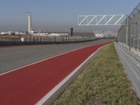 an empty track at a motorsports club with some red and white stripeing on it