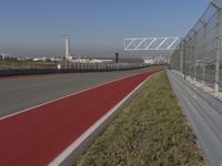 an empty track at a motorsports club with some red and white stripeing on it