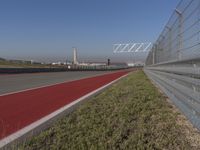 an empty track at a motorsports club with some red and white stripeing on it