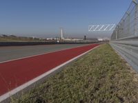 an empty track at a motorsports club with some red and white stripeing on it