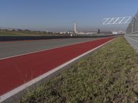 an empty track at a motorsports club with some red and white stripeing on it