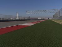 an empty track at a motorsports club with some red and white stripeing on it