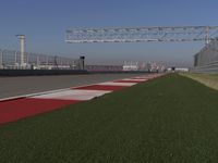 an empty track at a motorsports club with some red and white stripeing on it