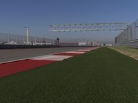 an empty track at a motorsports club with some red and white stripeing on it