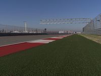 an empty track at a motorsports club with some red and white stripeing on it