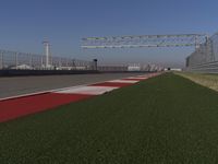 an empty track at a motorsports club with some red and white stripeing on it