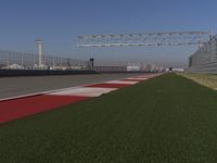 an empty track at a motorsports club with some red and white stripeing on it