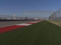 an empty track at a motorsports club with some red and white stripeing on it