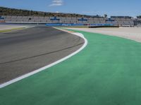 the green road and orange and white stripe line at an event near the racetrack and stadium