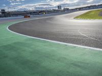 the green road and orange and white stripe line at an event near the racetrack and stadium