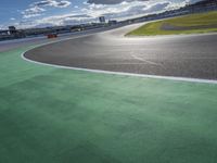 the green road and orange and white stripe line at an event near the racetrack and stadium