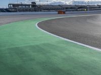 the green road and orange and white stripe line at an event near the racetrack and stadium