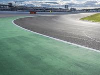 the green road and orange and white stripe line at an event near the racetrack and stadium