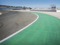 the green road and orange and white stripe line at an event near the racetrack and stadium