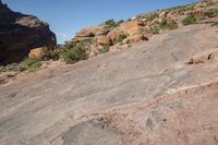 a man standing next to a large rock in a canyon with no vegetation on the rocks