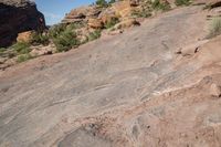 a man standing next to a large rock in a canyon with no vegetation on the rocks