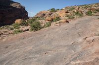 a man standing next to a large rock in a canyon with no vegetation on the rocks