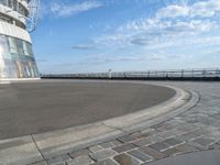 there is a black and white skateboarder riding in the empty place by the water