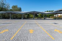 two white awnings in a parking lot with some trees on the ground,