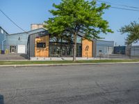 a yellow fire hydrant next to a fence and building with a large number 22 on it